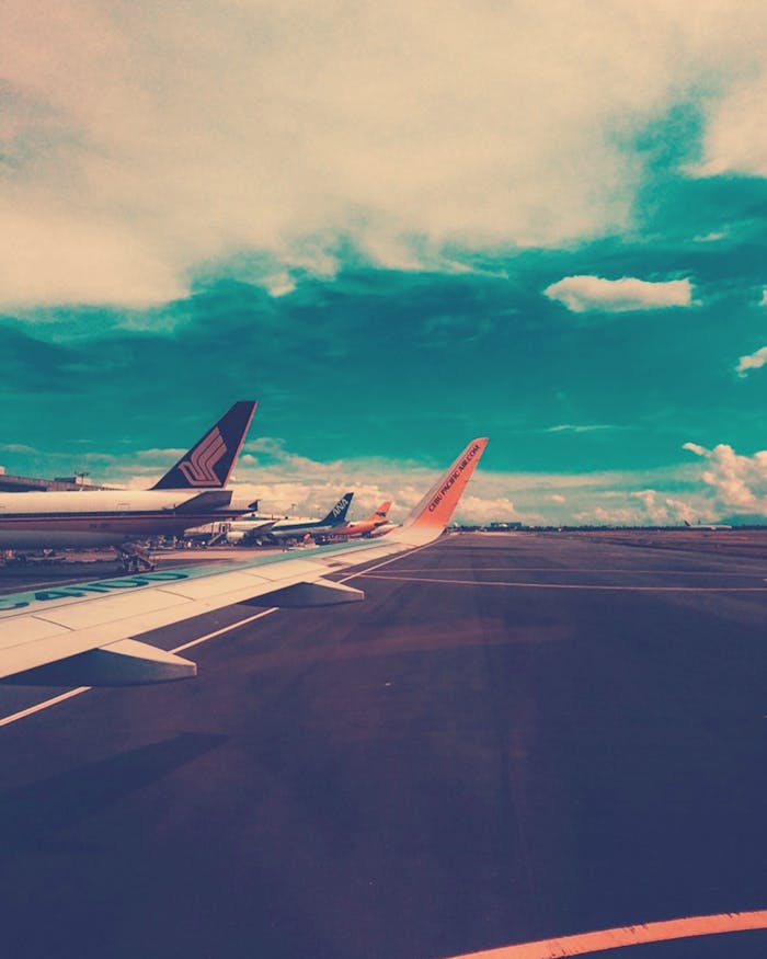 Plane on Airport Under Cloudy Sky at Daytime